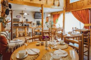 a dining room with wooden tables and chairs at Hostal Viento Sur in Coihaique