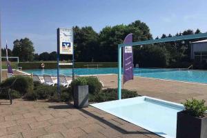 a swimming pool with a sign in front of it at Moderne Wohnung in der Heide in Winsen