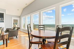 a dining room with a table and chairs and the ocean at Cape Point Retreat 7 Bedroom Home by KEES Vacations in Buxton