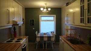 a kitchen with a table and a table and a window at Tangahús Guesthouse in Borðeyri