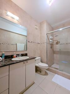 y baño con aseo, lavabo y ducha. en Yc l Apartamento 2BR - 3602, en Panamá