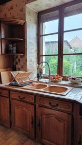 eine Küche mit einem Waschbecken und einem Fenster in der Unterkunft Maison familiale (10p) à 15 min du Zoo de Beauval in La Vernelle
