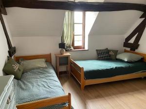 1 Schlafzimmer mit 2 Betten und einem Fenster in der Unterkunft Maison familiale (10p) à 15 min du Zoo de Beauval in La Vernelle