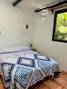 um quarto com uma cama com uma colcha azul e branca em Playa Car house em Playa del Carmen