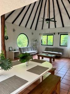uma sala de estar com sofás, mesas e janelas em Playa Car house em Playa del Carmen