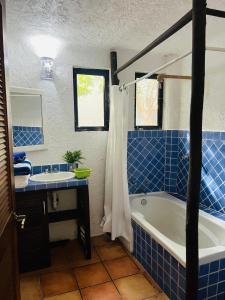 uma casa de banho em azulejos azuis com uma banheira e um lavatório em Playa Car house em Playa del Carmen