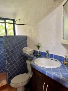 uma casa de banho em azulejos azuis com um WC e um lavatório em Playa Car house em Playa del Carmen