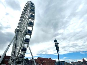 a large ferris wheel in a city with a street light at MMRent Mountain Room in Gdańsk