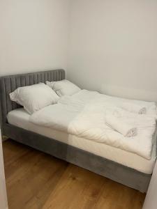 Una cama con sábanas blancas y almohadas. en ANETT, en Sulęcin