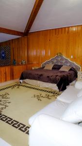 ein Schlafzimmer mit einem Bett in einer Holzwand in der Unterkunft Cabañas- Casas España in Mineral del Chico