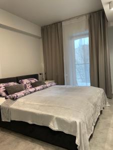 een slaapkamer met een groot bed en een raam bij Wenecjanska Comfort Apartment, free parking, self check-in 24h in Poznań