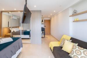 a living room with a couch and a bedroom at Elegant Studio - GRU 1506 in Guarulhos +50 photos