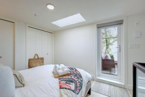 1 dormitorio con cama y ventana en West Coast Loft with Rooftop Patio + Harbour View, en Victoria