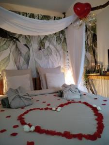 a bed with a heart made out of roses at Chambre d'hôtes jacuzzi L'envol du coquelicot 