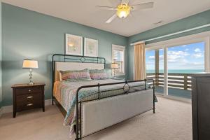 a bedroom with a bed with a view of the ocean at Cape Point Retreat 7 Bedroom Home by KEES Vacations in Buxton +75 photos