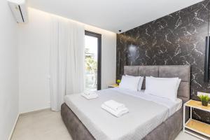a bedroom with a large bed with white towels on it at Varkiza Luxury Suites by Raise in Vari