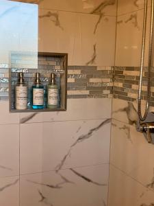 a bathroom with three shampoo bottles on a shelf at The Verna Mae in Los Angeles