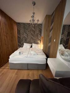 1 dormitorio con cama blanca y lámpara de araña en ANETT, en Sulęcin