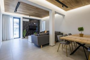 a living room with a table and a dining room at Varkiza Luxury Suites by Raise in Vari