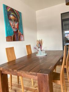 einen Holztisch mit Stühlen und ein Gemälde an der Wand in der Unterkunft SUITE-DREAMS APARTMENT - Innenstadt in Hannover