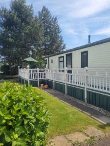 una casa con una valla blanca y un patio en Sunrise Holidays Skegness - Emerald en Skegness