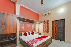 a bedroom with a bed and orange walls at OYO Flagship Darsh Residency in Dhanbād