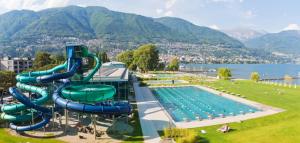 a swimming pool with a water slide in a park at CASA DOYA - Appartamento vintage in Muralto
