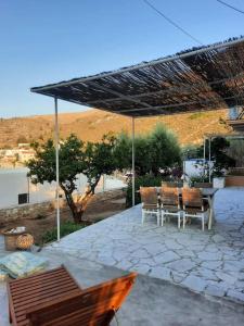 een patio met een tafel en stoelen onder een dak bij Villa Kochili. in Symi