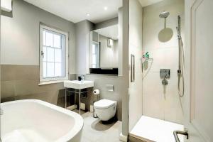 a bathroom with a tub and a toilet and a sink at Welcome London St Martin's in London