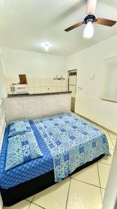 a bedroom with a bed with a blue comforter at Casa 4 hospedagem seropedica in Seropédica