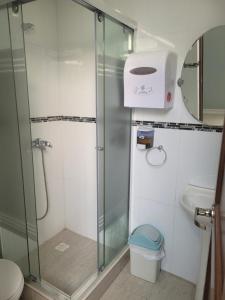 a bathroom with a shower and a toilet and a sink at Hostal Ostello Amadeus in Arica