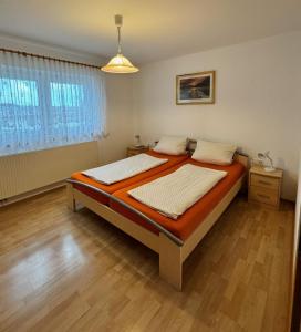 Un dormitorio con dos camas y una ventana. en Ferienhaus Eichhölzle, en Münsingen