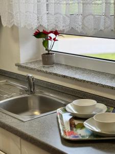 a kitchen sink with two dishes and a window at Ferienhaus Eichhölzle in Münsingen
