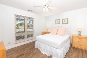 Un dormitorio blanco con una cama y una ventana. en Seascape Town Home- Boardwalk 193, en Destin