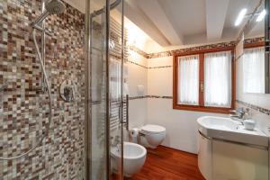 y baño con ducha, aseo y lavamanos. en Glass House - Loft 2 minutes to Rialto Bridge & View, en Venecia
