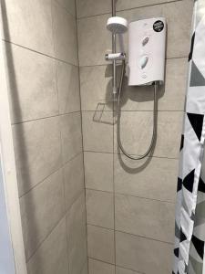 a shower with a shower head in a bathroom at The Snug - City Centre Studio in York