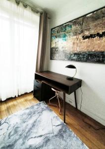 a desk with a lamp on it in a room at Luxueux appartement sur jardin in Paris