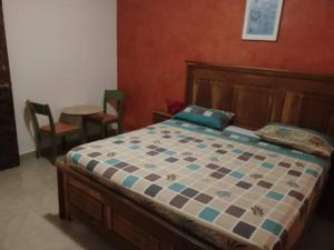 a bedroom with a bed and a table and chairs at Chambre Orange in Mbour