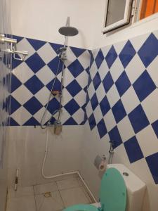 a bathroom with a blue and white checkered wall at Chambre Orange in Mbour