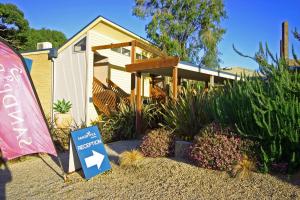 a small house with a sign in front of it at Sandpiper Motel Apollo Bay in Apollo Bay