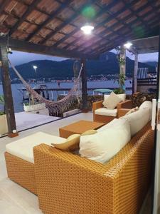 un divano in vimini su un balcone con amaca di Casa na Ilha Jardim pé na areia a Rio de Janeiro