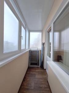 een hal met twee ramen en een ventilator. bij 4 ліжка з балконом Документи для відряджень Мережа Alex Apartments Безконтатне заселення 24-7 in Poltava