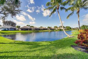 a pond in a yard with palm trees and houses at Naples Vacation Rental Home with Heated Private Pool in Naples