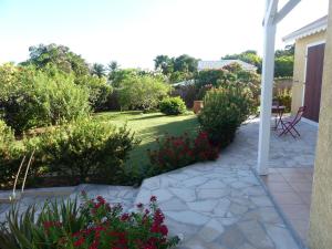 een patio met een tuin met bloemen en planten bij Villa Magnifique piscine & jardin in Baie-Mahault