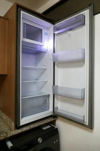 an empty refrigerator with its door open in a kitchen at Ecusuites Penthouse Vía Costa Ceibos Puerto Azul in Guayaquil