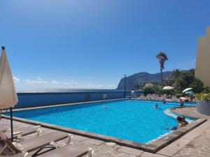 a large swimming pool with people in the water at By the Atlantic Apartments 3-bedroom in Funchal