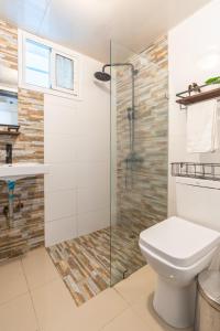 a bathroom with a toilet and a glass shower at Precioso Apartamento con terraza y Jacuzzi privado in Jacagua
