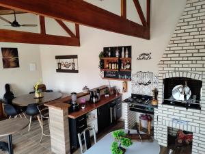 a kitchen with a table and a fireplace at Linda Chacara com 2 Chalés e 1 suíte em Boituva in Boituva