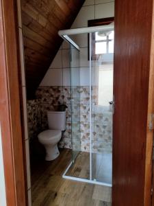 ein Badezimmer mit einem WC und einer Glasduschkabine in der Unterkunft Linda Chacara com 2 Chalés em Boituva in Boituva