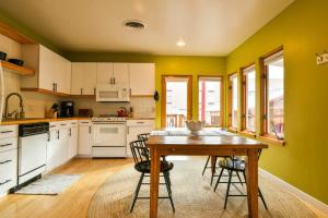 uma cozinha com armários brancos e uma mesa de madeira em Hazel @ Stella Ruby Cottages - Steps to Downtown! em Moab
